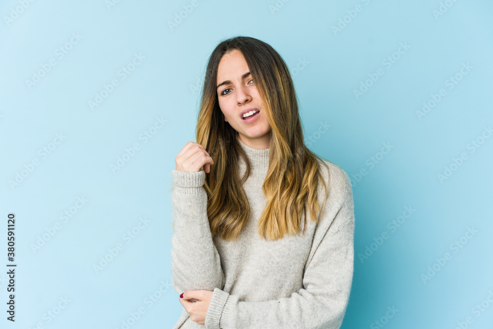Young caucasian woman isolated on blue background massaging elbow, suffering after a bad movement. Young caucasian woman isolated on blue background massaging elbow, suffering after a bad movement.