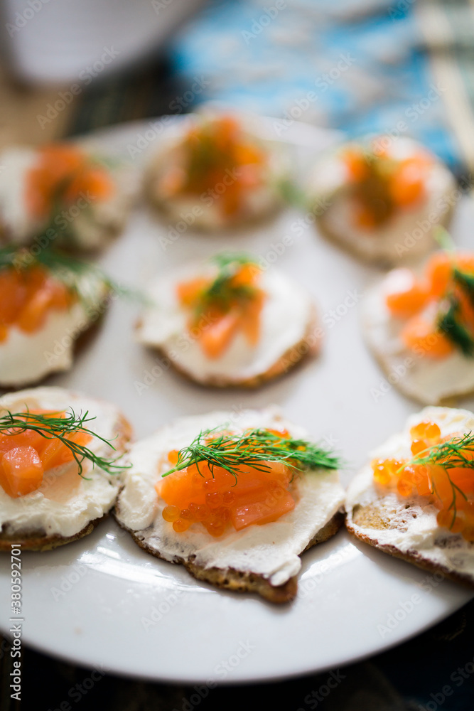 Close up of dish of blinis with sour cream, smoked salmon, caviar and fresh dill on plate Close up of dish of blinis with sour cream, smoked salmon, caviar and fresh dill on plate