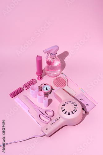 Vintage style layout with pink hairdryer, scissors, bottle, make up and cassette tape on pastel background. Retro fashion aesthetic. Art direction, flat lay, isometric. Minimal 80'st concept.