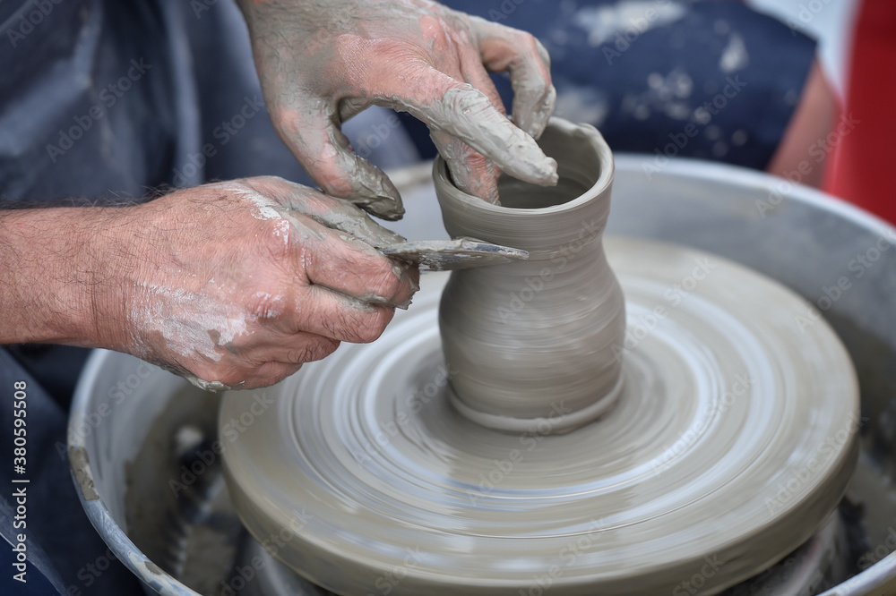 Detail with hands of an artist modeling a bowl on a pottery wheel Detail with hands of an artist modeling a bowl on a pottery wheel