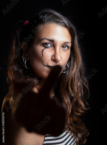 Young brunette Woman With Face paint Showing Middle Fingers
