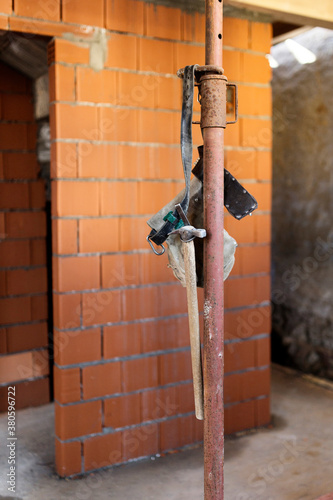 Work tools belt hanging from pole inside apartment under construction photo