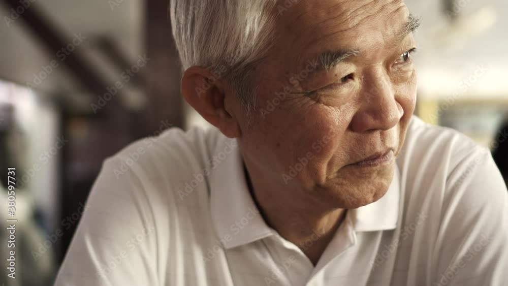Asian senior elder man sitting looks happy in retro sepia tone close up shot Asian senior elder man sitting looks happy in retro sepia tone close up shot