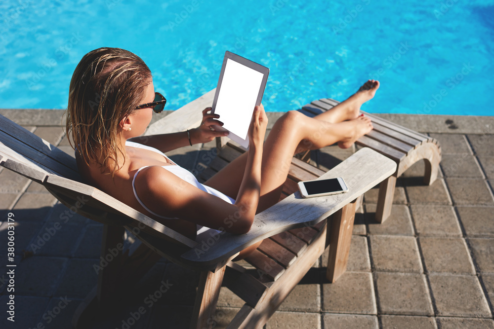 Modern lady with tablet on poolside