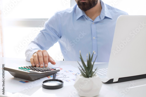 Businessman or accountant working on laptop with business document, chart diagram and calculator. photo