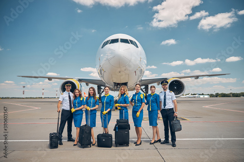 Foto Airline workers with travel suitcases standing outdoors in airfield