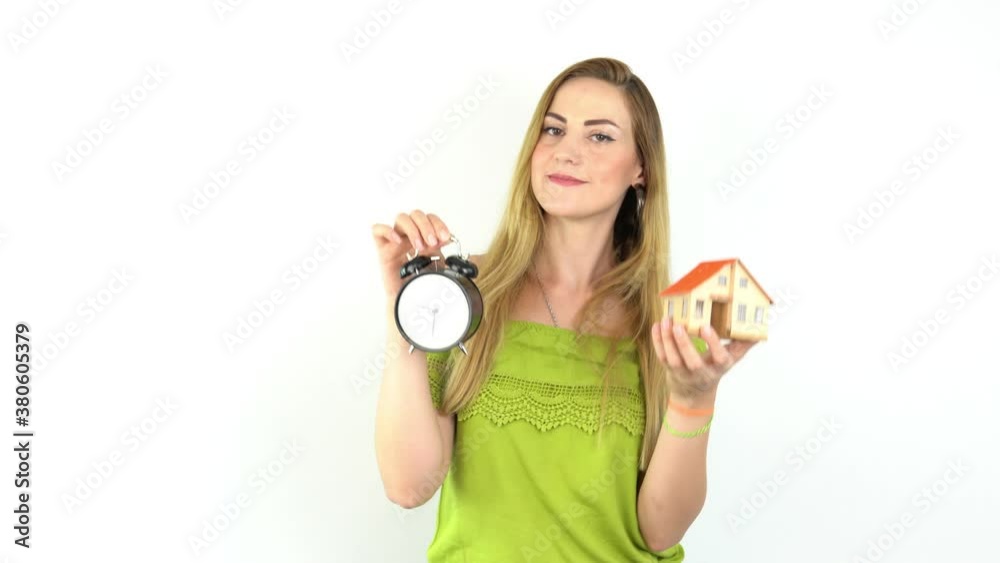 Hands of young woman holding model house with alarm clock, real estate insurance and banking concept. Hands of young woman holding model house with alarm clock, real estate insurance and banking concept.