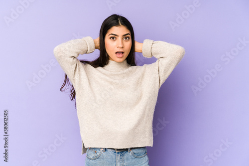 Young indian woman isolated on purple background screaming, very excited, passionate, satisfied with something. © Asier