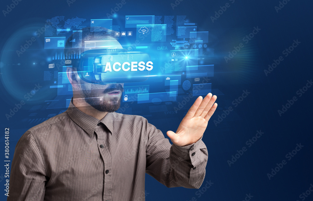 Businessman looking through Virtual Reality glasses with ACCESS inscription, innovative security concept Businessman looking through Virtual Reality glasses with ACCESS inscription, innovative security concept