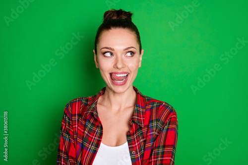 Close-up portrait of her she nice attractive pretty lovely cheery dreamy girl in checked shirt licking lip fantasizing overthinking isolated on bright vivid shine vibrant green color background © deagreez
