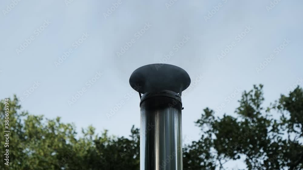 close up of smoke rising from cabin chimney