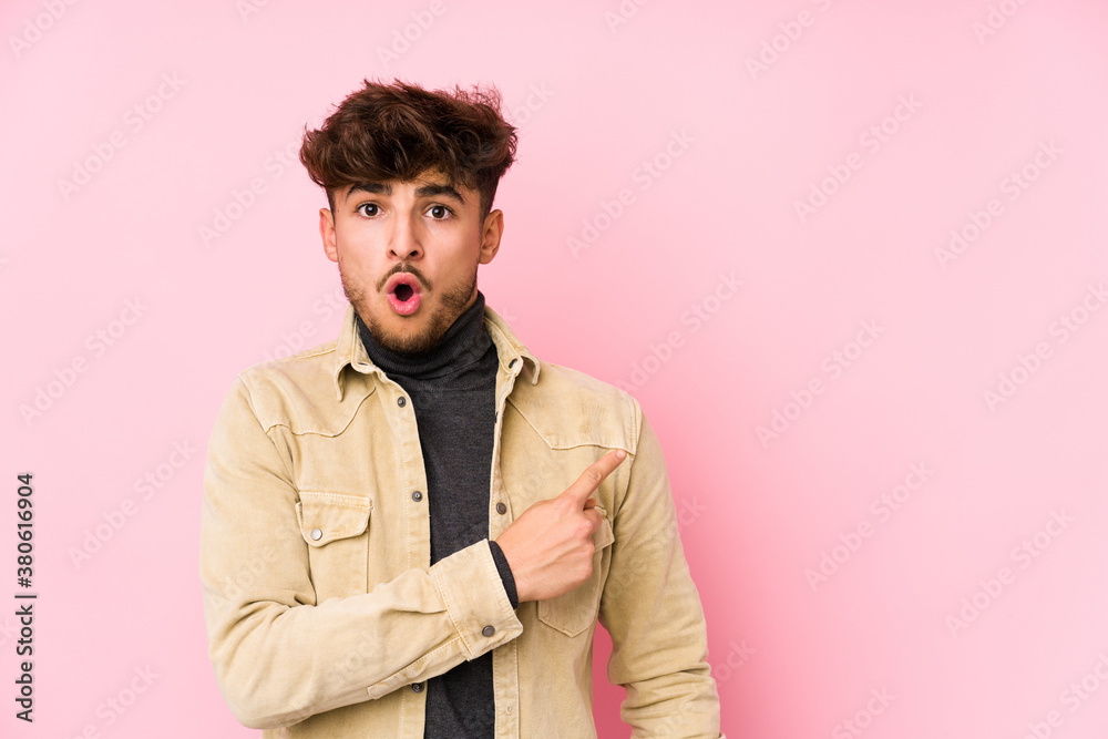 Young arabian man posing in a background isolated pointing to the side Young arabian man posing in a background isolated pointing to the side