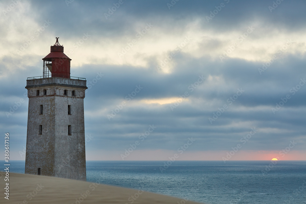 Closeup of a lighthouse with the sunset in the back