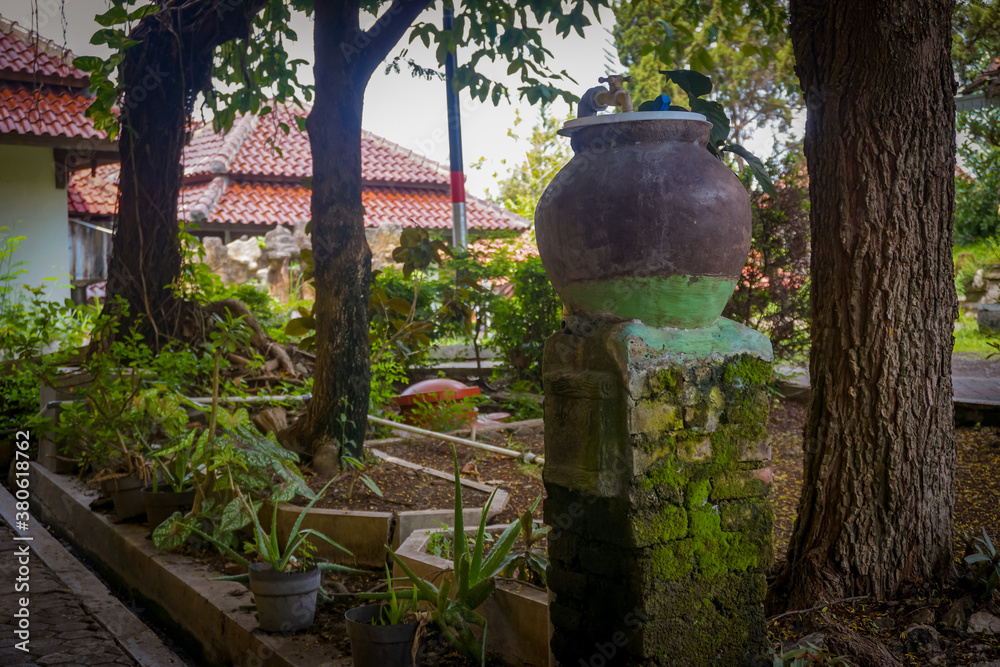 Obraz premium A barrel made of earth. Filled water in the countryside. Javanese tradition