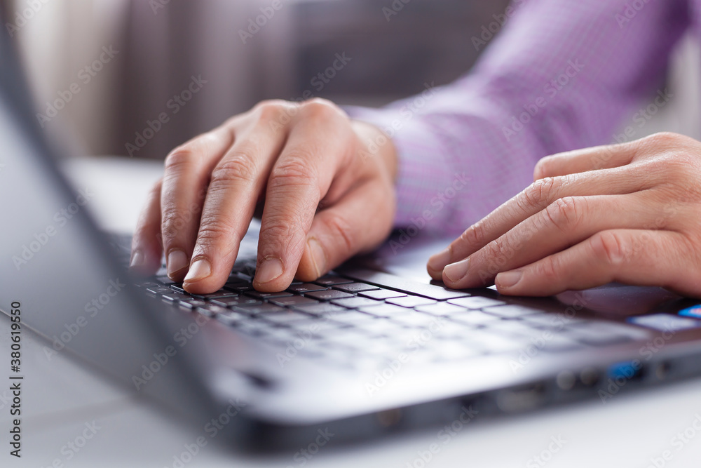 Male executive hands typing and scrolling on a laptop computer device with blur background. Working online from home.
Male executive hands typing and scrolling on a laptop computer device with blur background. Working online from home.