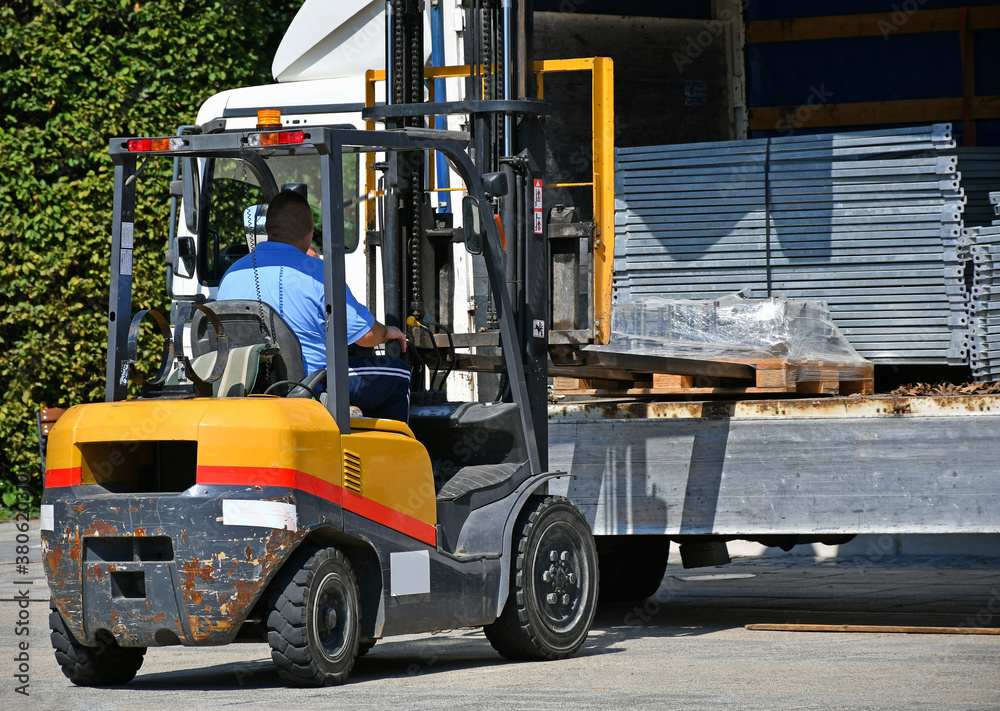Fork lift unloading a truck at the construction site