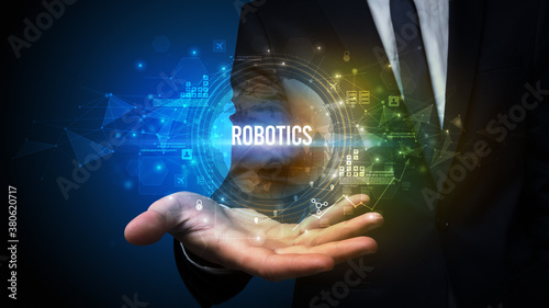 Elegant hand holding ROBOTICS inscription, digital technology concept