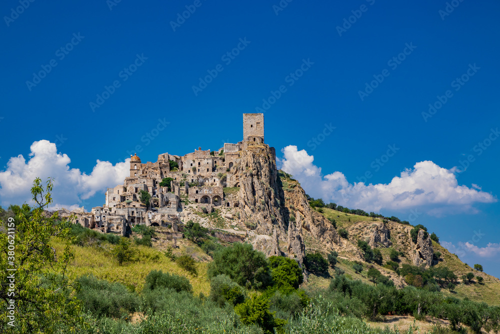 Craco, Matera, Basilicata, Italy. The ghost town destroyed and abandoned following a landslide. View of the remains and ruins of the ancient village built on the top of the hill. Watchtower at the top