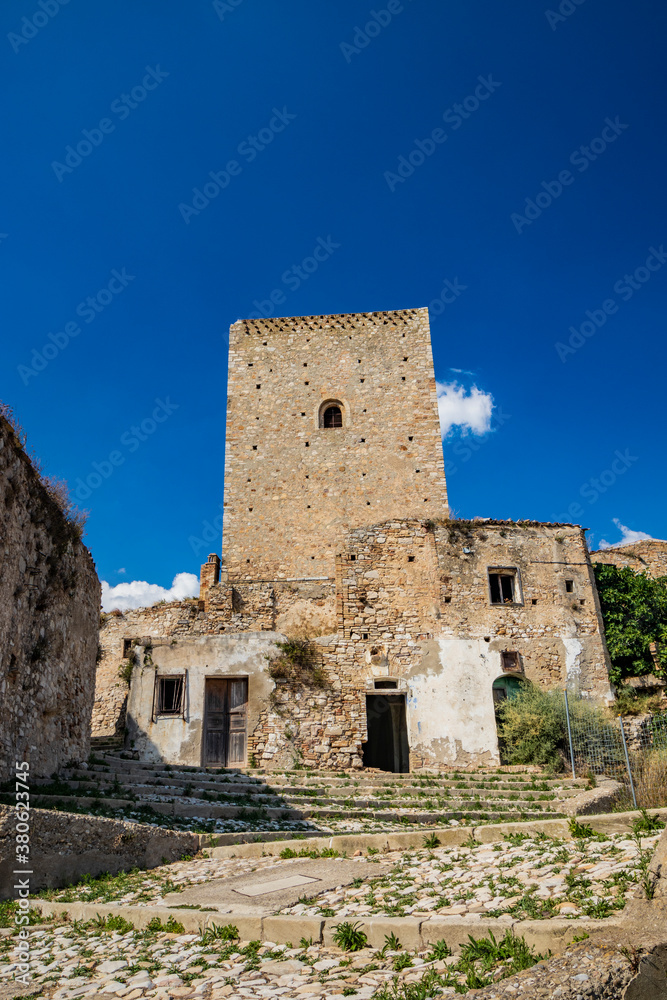 Craco, Matera, Basilicata, Italy. The ghost town destroyed by a landslide. The collapsed houses and the remains invaded by vegetation. The ancient watchtower still standing overlooks the city.