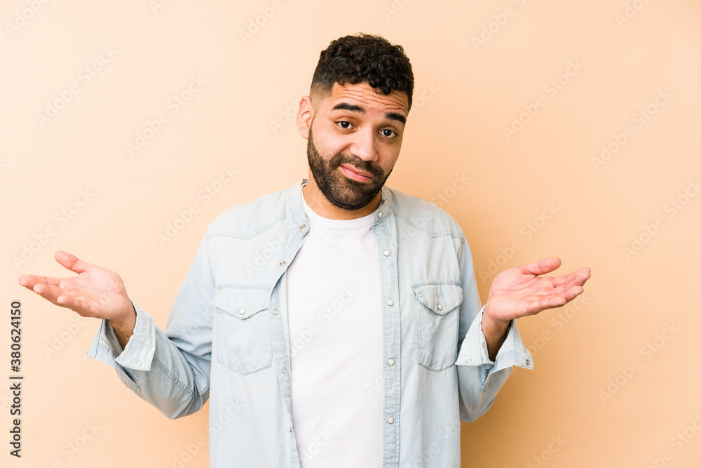 Young mixed race arabic man isolated doubting and shrugging shoulders in questioning gesture. Young mixed race arabic man isolated doubting and shrugging shoulders in questioning gesture.