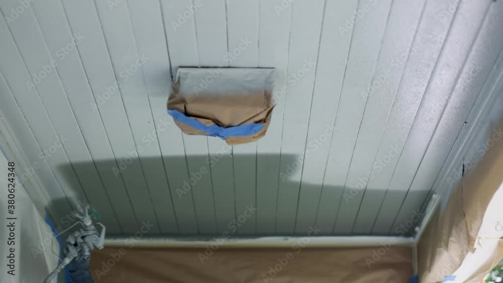 Man Painting The Ceiling With A White Color Using Paint Sprayer