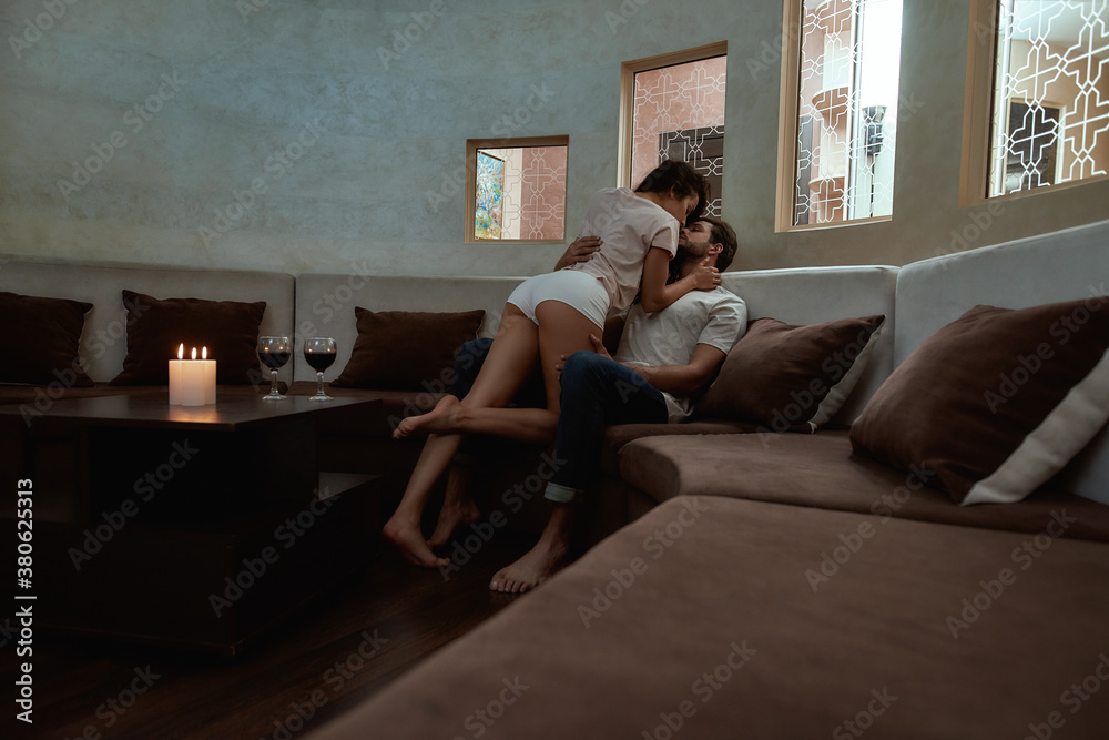 Temptation. Full-length shot of young sexy man and woman kissing before having sex on the couch Temptation. Full-length shot of young sexy man and woman kissing before having sex on the couch