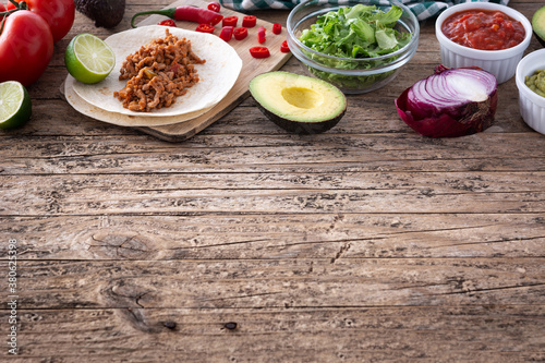 Mexican tacos ingredients on wooden table.Copy space	