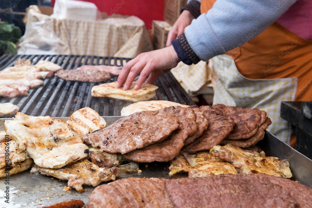 Traditional serbian street food (rostilj) - pljeskavica, cevapi, grilled chicken breast, bbq chicken wings and homemade sausages served with fresh bakery (lepinja)
