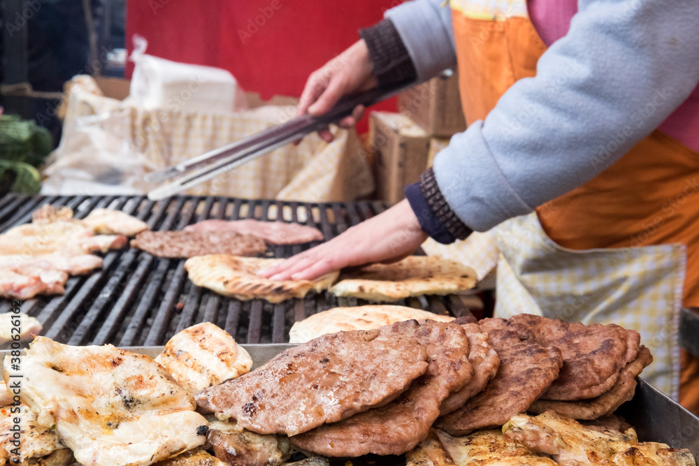 Traditional serbian street food (rostilj) - pljeskavica, cevapi, grilled chicken breast, bbq chicken wings and homemade sausages served with fresh bakery (lepinja)