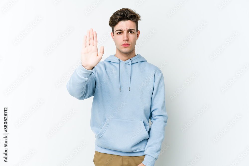 Young caucasian man isolated on white background standing with outstretched hand showing stop sign, preventing you. Young caucasian man isolated on white background standing with outstretched hand showing stop sign, preventing you.