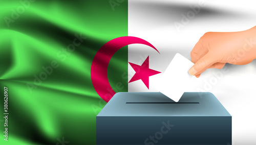 Male hand puts down a white sheet of paper with a mark as a symbol of a ballot paper against the background of the Algeria flag. Algeria the symbol of elections