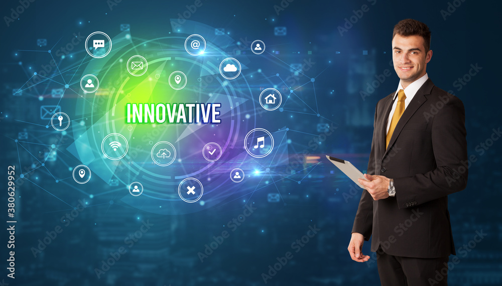 Businessman thinking in front of technology related icons and INNOVATIVE inscription, modern technology concept Businessman thinking in front of technology related icons and INNOVATIVE inscription, modern technology concept