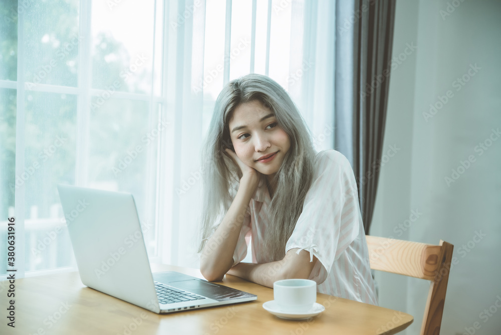 Lazy bored asian woman using laptop in the morning. Lazy bored asian woman using laptop in the morning.
