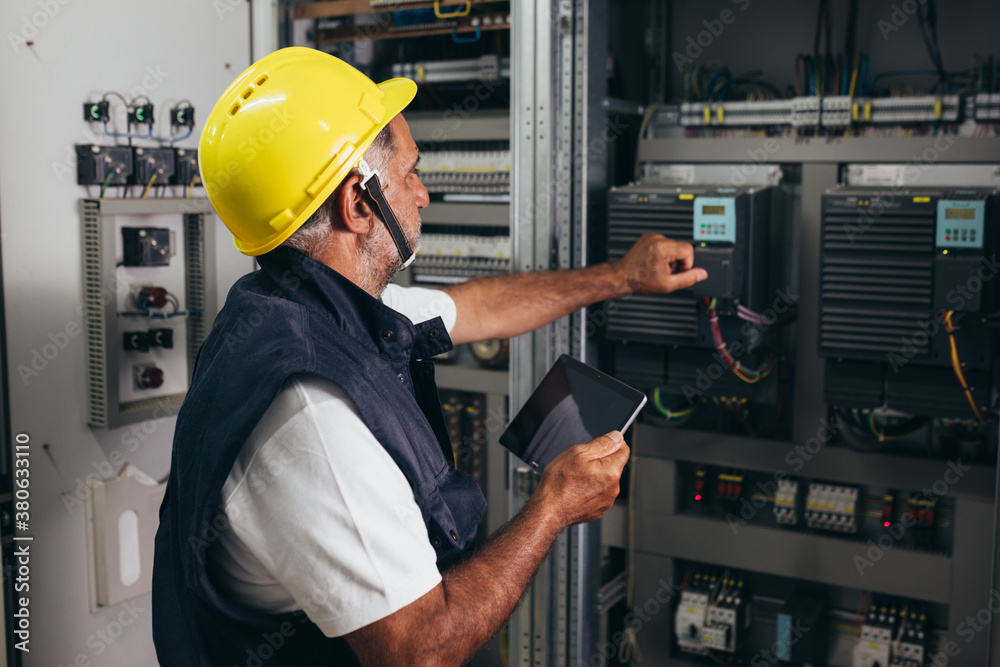 © cherryandbees - engineer checking the electrical cabinet at control room
