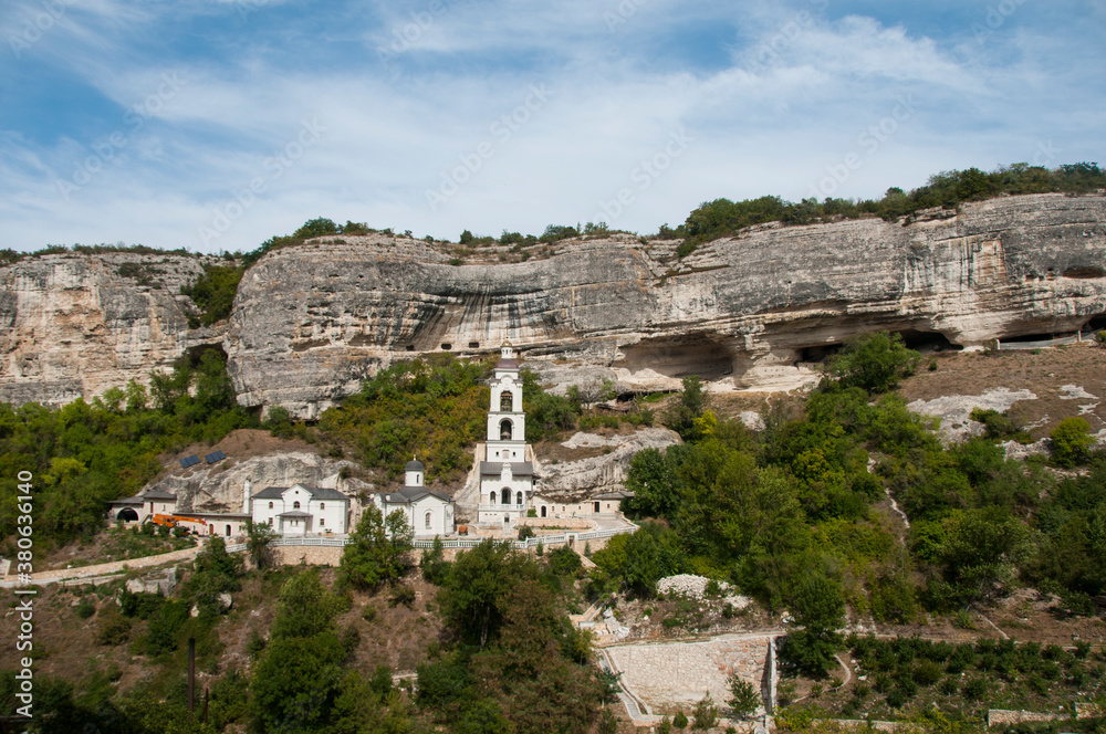 Anastasia Uspensky cave monastery in Bakhchysarai. Unique ancient cave monastery. Orthodox Church with white tower on the background of a rock.