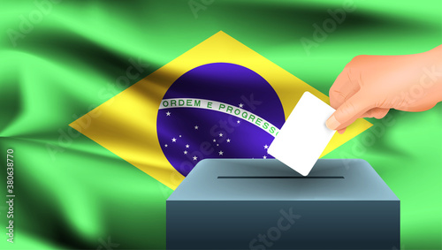 Male hand puts down a white sheet of paper with a mark as a symbol of a ballot paper against the background of the Brazil flag. Brazil the symbol of elections