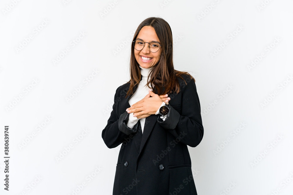 Young mixed race business woman isolated on white background has friendly expression, pressing palm to chest. Love concept. Young mixed race business woman isolated on white background has friendly expression, pressing palm to chest. Love concept.
