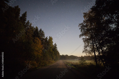 Long dirt road and starry sky at night moonlight © Juhku