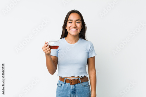 Young mixed race indian holding a tea cup happy, smiling and cheerful.