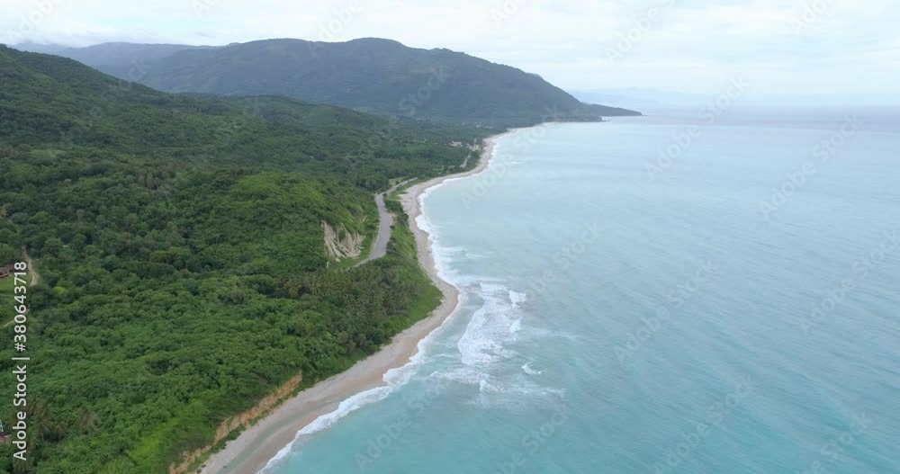 Backward flight with drone overlooking the beautiful beach los patos in barahona, blue waters cloudy day, beautiful mountains Backward flight with drone overlooking the beautiful beach los patos in barahona, blue waters cloudy day, beautiful mountains