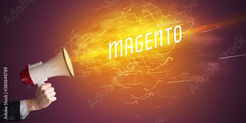 Young girld shouting in megaphone with MAGENTO inscription, online shopping concept photo
