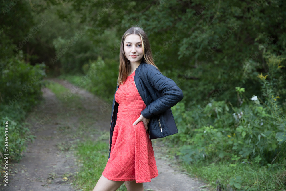 Portrait of a beautiful brunette outdoors on a green forest background. Portrait of a beautiful brunette outdoors on a green forest background.