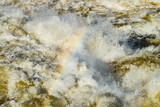Splashing water waves with rainbow on the fast river