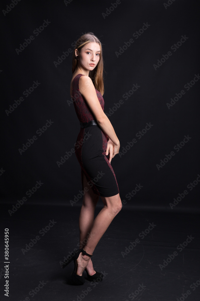 Beautiful brunette in an elegant dress on a black background. Beautiful brunette in an elegant dress on a black background.