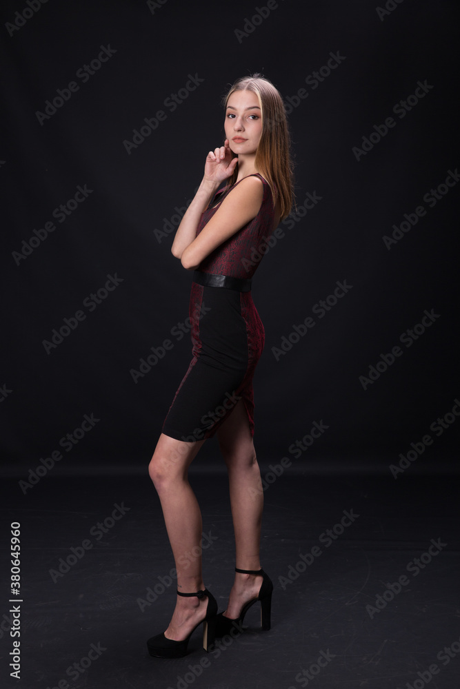 Beautiful brunette in an elegant dress on a black background. Beautiful brunette in an elegant dress on a black background.