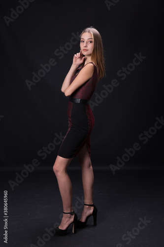 Beautiful brunette in an elegant dress on a black background. © Fotostudijas.lv