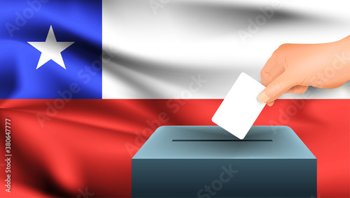Male hand puts down a white sheet of paper with a mark as a symbol of a ballot paper against the background of the Chile flag. Chile the symbol of elections