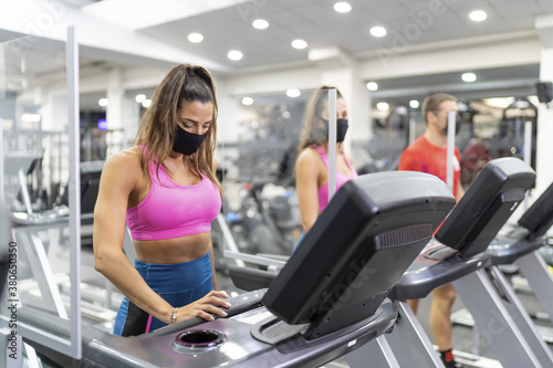 Closeup of people exercising in the gym in facial masks - concept of new normal photo