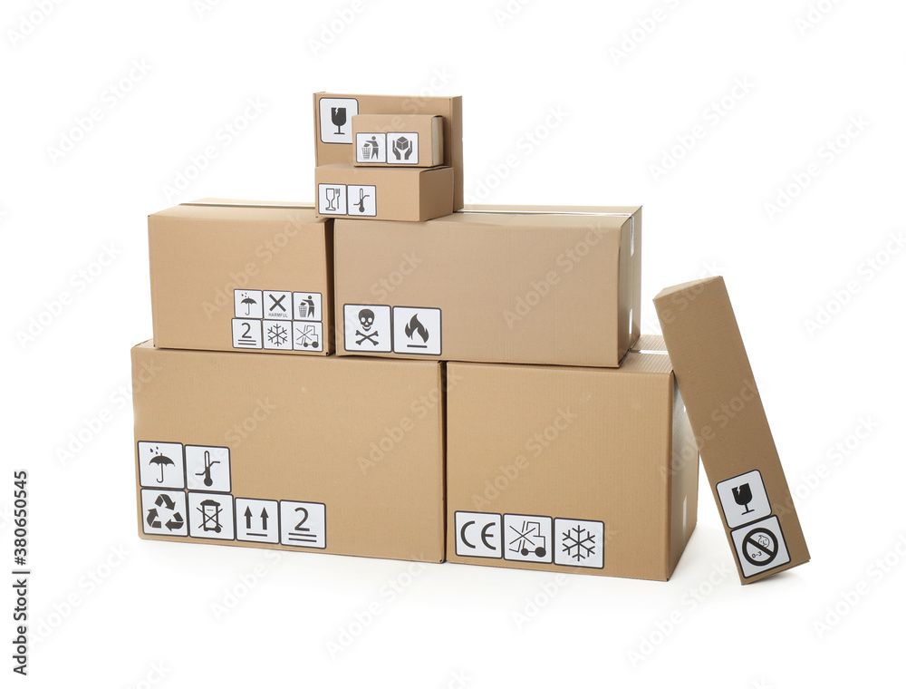 Fototapeta premium Stack of cardboard boxes with different packaging symbols on white background. Parcel delivery