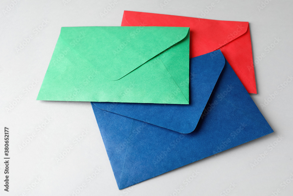 Colorful paper envelopes on light grey background. Mail service Colorful paper envelopes on light grey background. Mail service